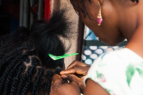 Grace braider working on a client in the salon